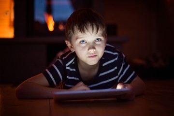 Eight years old boy using digital tablet