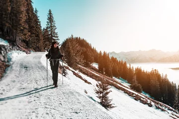 Printed kitchen splashbacks Winter sports Woman hiking along snowy trail in mountains