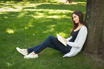 Young woman reading book in park