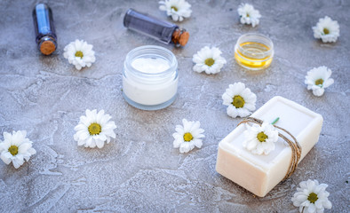 organic cosmetics with camomile on stone background