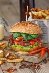 Big tasty burger and fries with on background on the wooden table