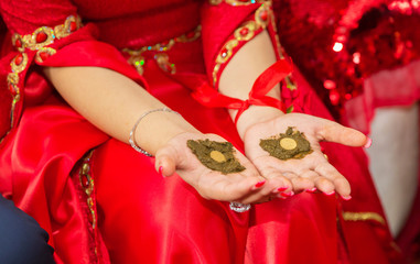 They put their hands henna of the bride . Drawing henna at the Henna party. They put money in their hands