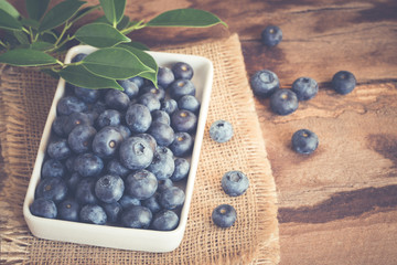 Blueberry in a white bowl on wood table