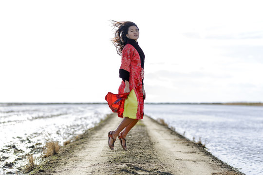 Mujer joven oriental cerca del mar levitando