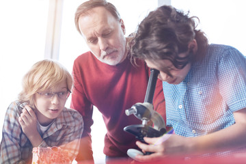 Scientific mentor. Nice attentive awesome professor guiding young boys who being enthusiastic about biology and studying bacteria in lab