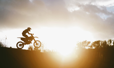 Extreme Motocross MX Rider riding on dirt track on a sunny late summer day on public training...
