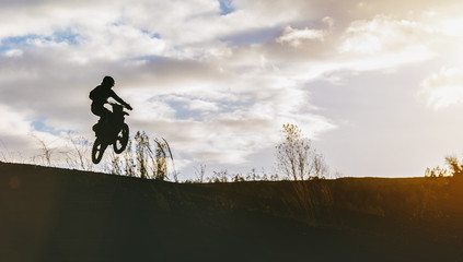 Extreme Motocross MX Rider riding on dirt track on a sunny late summer day on public training...