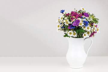 Wildflowers in white ceramic jug.