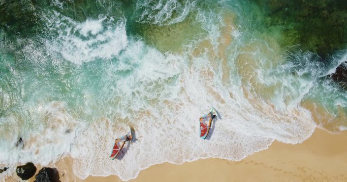 Cinematic aerial view of windsurfers on the beach