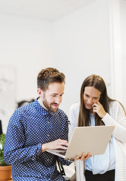 Man showing laptop to coworker