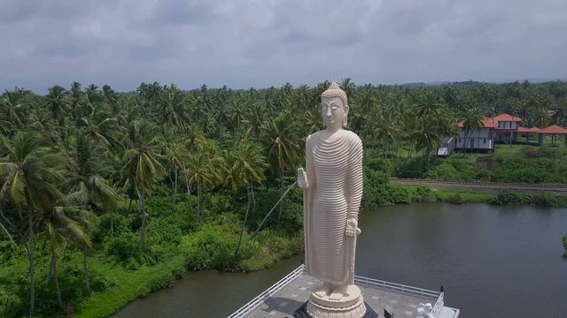 Big statue of Buddha near lake sunset drone footage