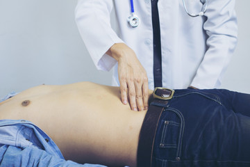 Close-up of pediatrician's hands diagnosing painful stomach selective focus.