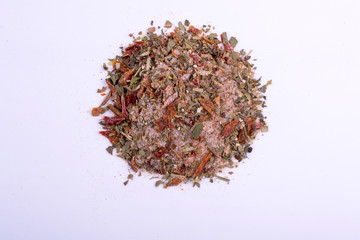 A pile of a red pizza seasonings spice mix. Isolated on white background. Spices consist dried paprika chili pepper black pepper basil coriander onion garlic dried vegetables