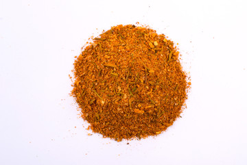 A pile of a yellow spice mix for chicken  . Isolated on white background. Spices consist paprika...