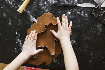 Hands of girl cutting dough forms