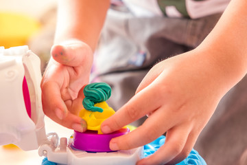Children playing dough with mold to make many funny shapes from their hands
