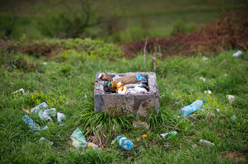 Illegal dumping in natural enviroment. Tin cans and plastic bottles and other items illegally dumped in forest.