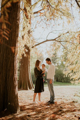 Happy family with baby boy in autumn park