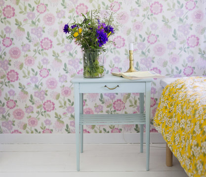 Nightstand with flowers in retro bedroom