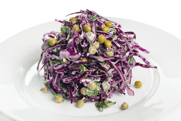 salad of purple cabbage with green peas and parsley on a white plate