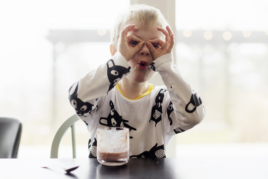 Young boy fooling around at table