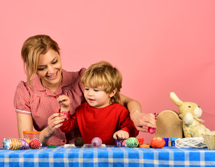 Obraz premium Easter and happy moments concept. Mother and son painting eggs