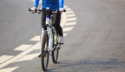 Fototapeta na wymiar Young Woman Cyclist Riding Mountain Bike on city road