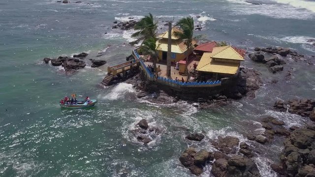 Buddhist temple on rocks in ocean drone footage