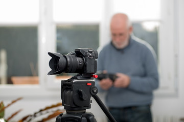 close-up of a camera on  tripod, photographer background