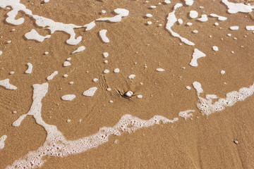 Waves with foam blue  sea on a sunny sandy beach in resort on summer vacation rest.