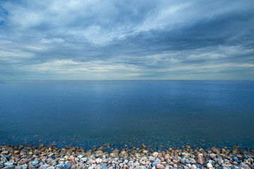 Calm on the sea. Rocky shore. Sky horizon above the water. It's a nasty day. Calm sea.