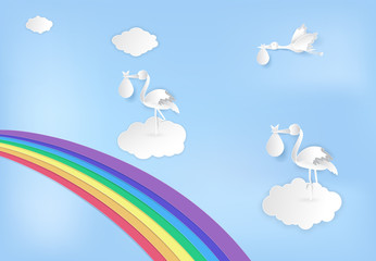 Paper art of stork flying with baby and rainbow on blue sky paper cut style illustration