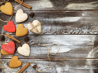 Lovely heart shaped ginger cookies with spice on vintage wooden background. Homemade backing. Cookie on the valentine's day. Flat lay, top view.