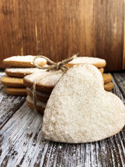 Fototapeta na wymiar Heart shaped ginger cookies with twine on wooden background. Homemade backing. Love or Valentine's day concept. 
