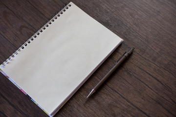 Closeup book and pen on wooden background