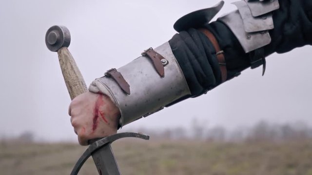The hand of the knight woman in the wounds that holds the sword