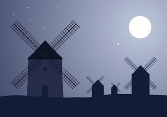 Typical Spanish windmills under the moon and stars