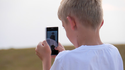 excited boy using smartphone - obrazy, fototapety, plakaty