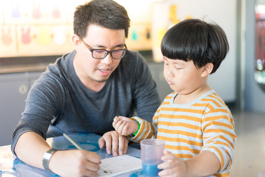 Father and son are painting.