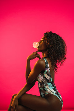 Attractive black woman blowing gum bubble