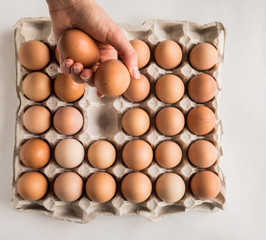 Hand folding out eggs in the package.