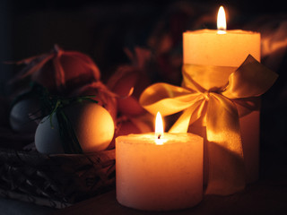 Easter composition. Candles burn in the dark.