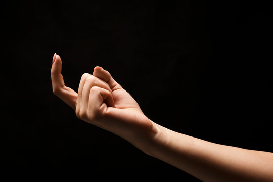 Female hand beckoning isolated on black background
