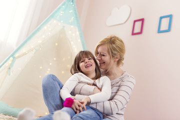 Mother holding and hugging her daughter