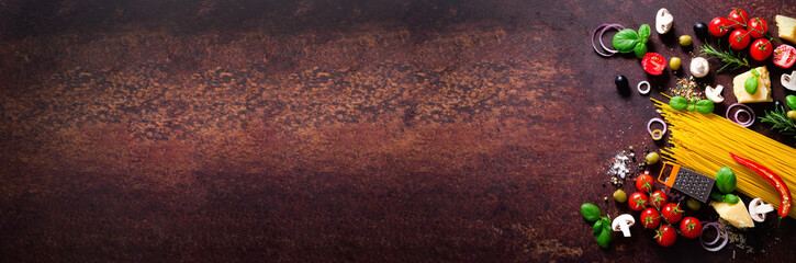 Food ingredients for italian pasta, spaghetti on brown dark background. Copy space of your text. Banner.