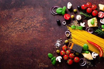 Food ingredients for italian pasta, spaghetti on brown dark background. Copy space of your text