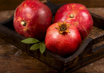 Ripe pomegranate fruits on the wooden background