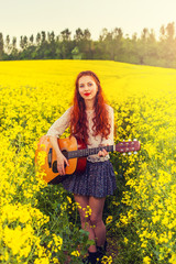 Fototapeta premium Young ginger hair girl in 70s style with acoustic guitar
