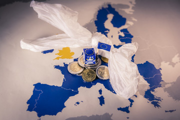 EU map with euro coins and a plastic bag symbolizing european plastic tax regulation.
