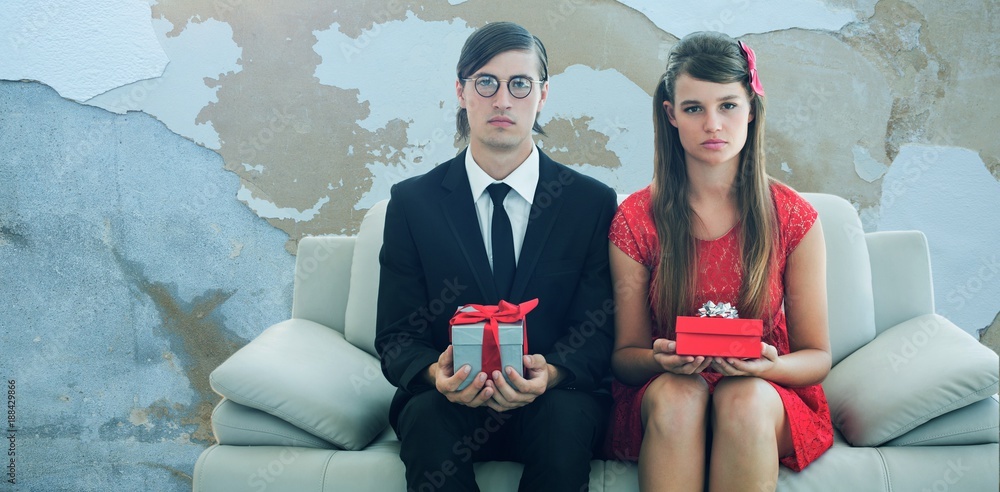 Poster composite image of unsmiling geeky couple with gift